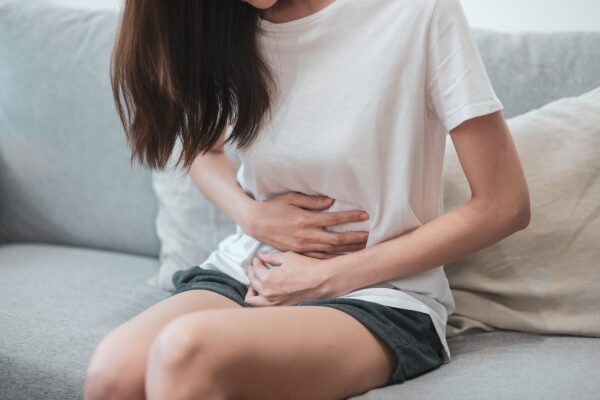 お腹を抑える女性
